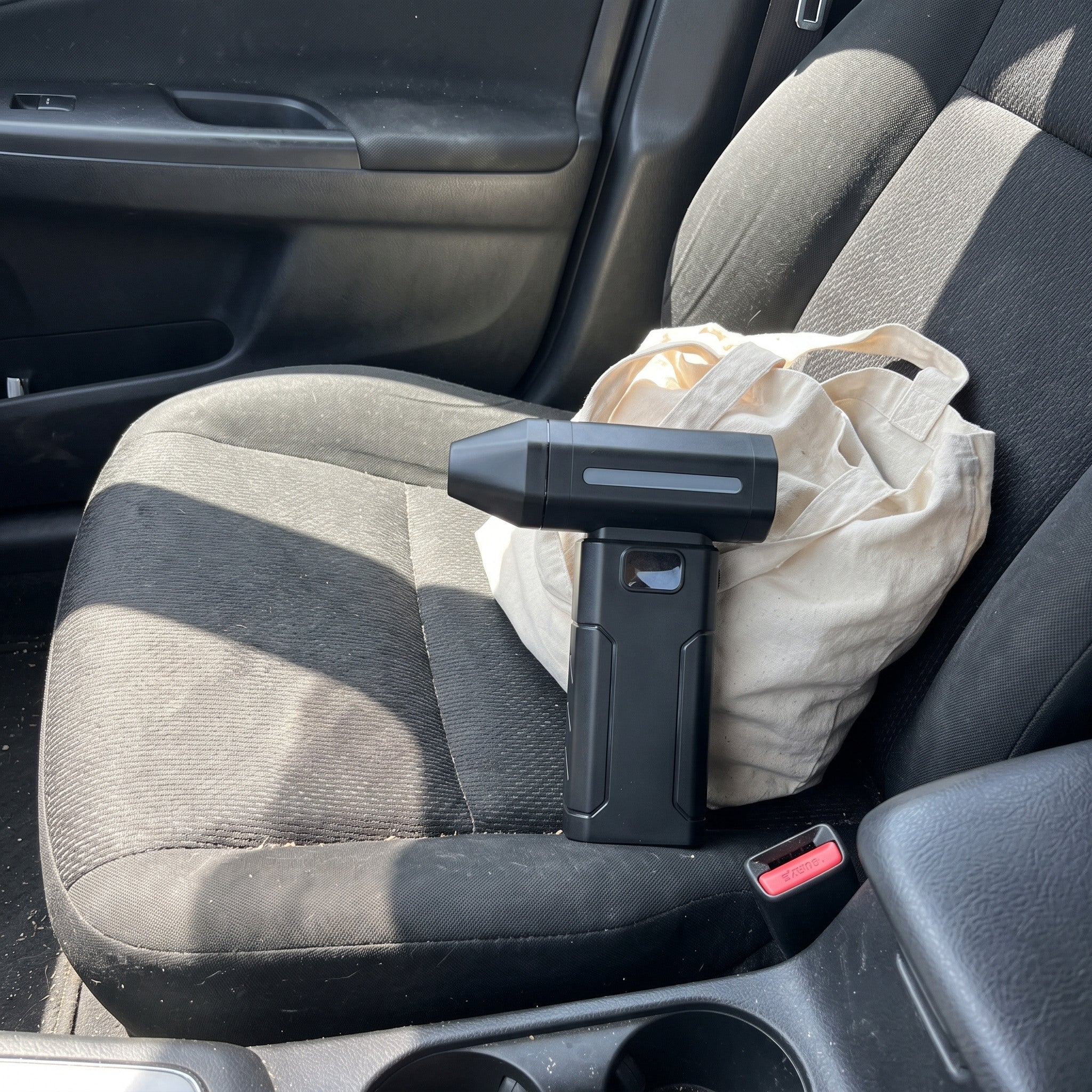 Black ClearJet handheld blower in an everyday dust-cleaning setting 4