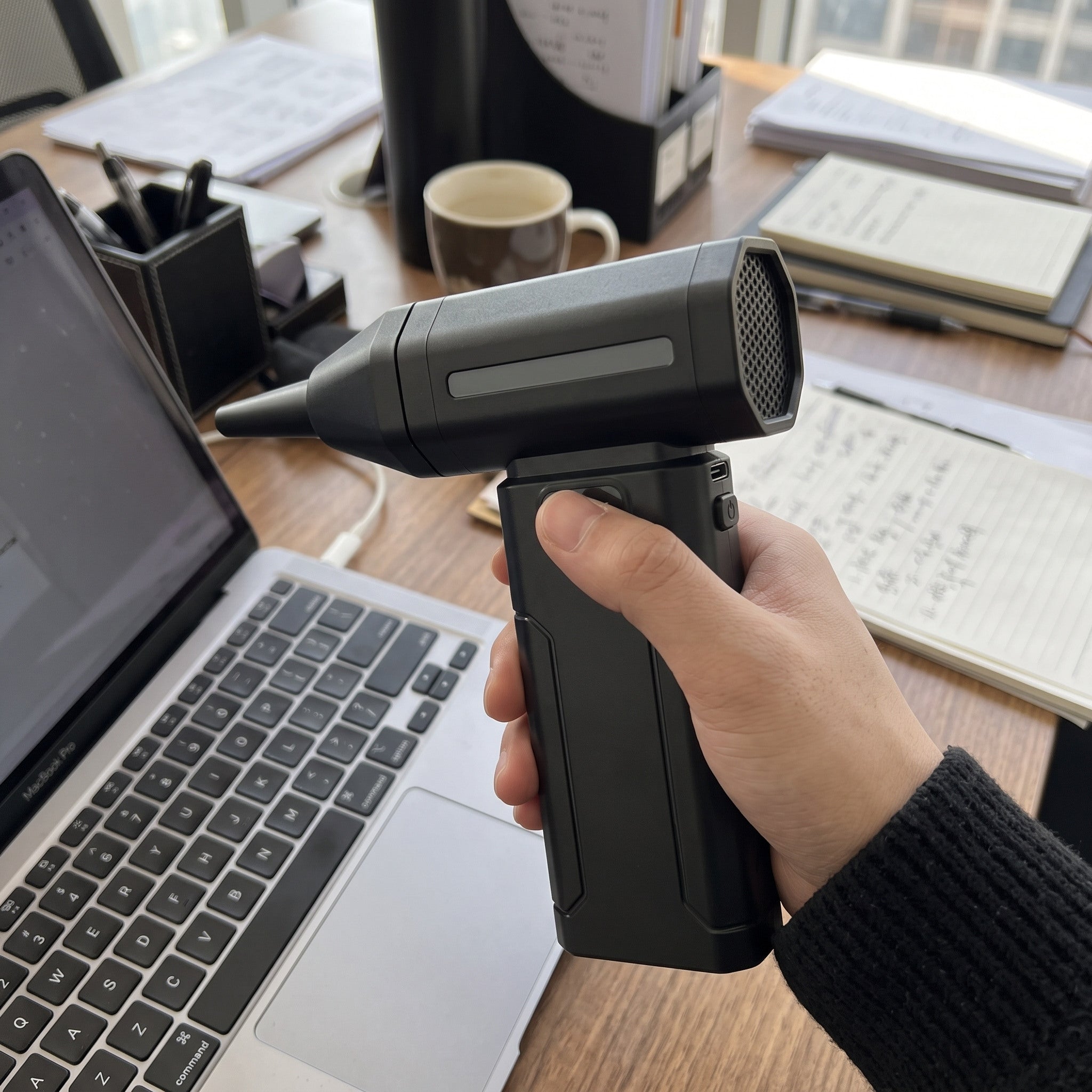 Black ClearJet handheld blower in an everyday dust-cleaning setting 5