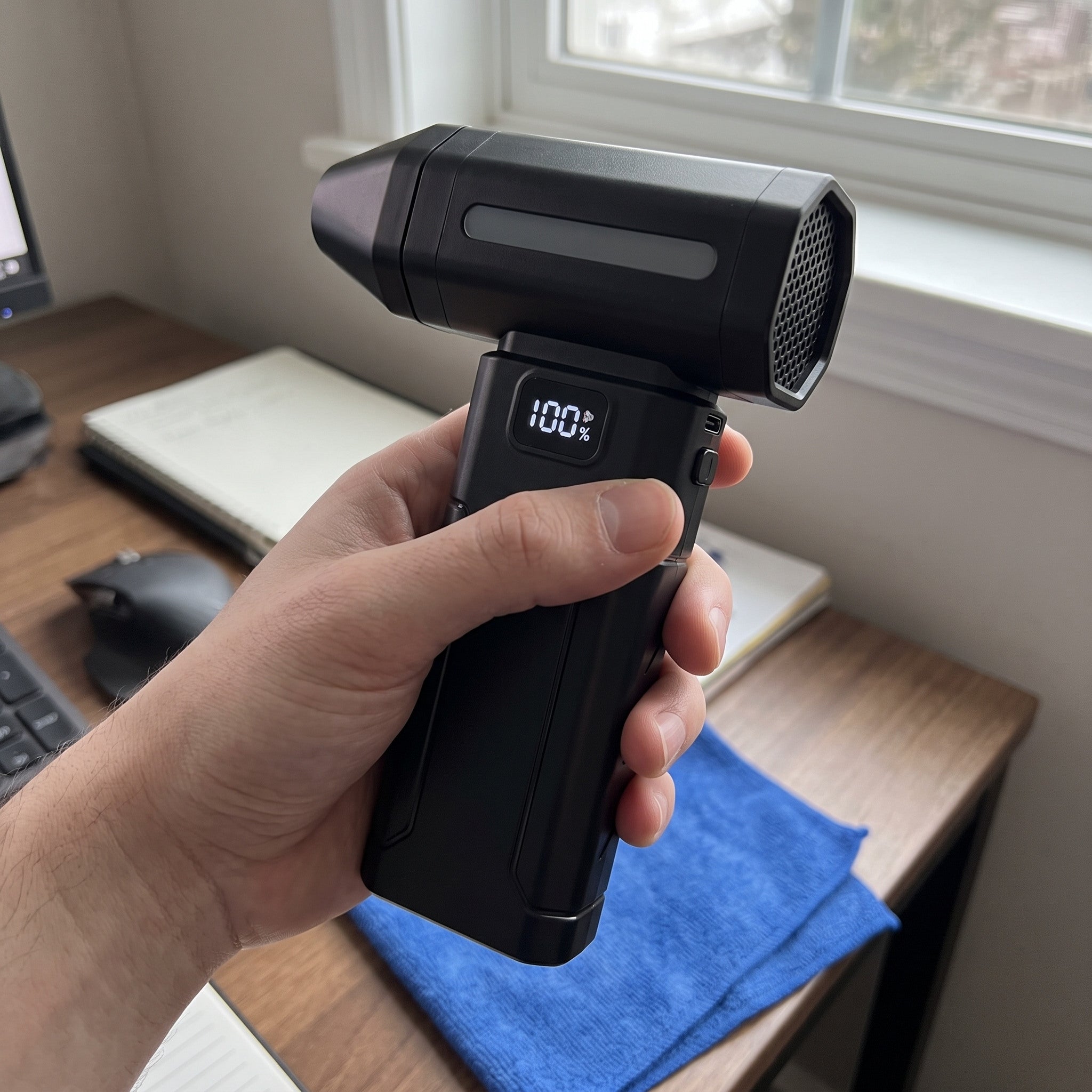 Black ClearJet handheld blower in an everyday dust-cleaning setting 7